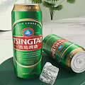 Tsingtao Beer Cans Display With Ice Cubes On Green Background And Round Decor
