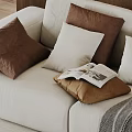 Brown And White Decorative Pillows On Beige Sofa With Open Magazine