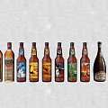 Assorted Wine and Beer Bottles With Glasses in Colorful Display Arrangement