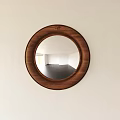 Round Mirror with Wooden Frame Hanging on White Wall Reflecting Empty Room with Dark Floor