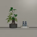 Fern Plant in Gray Pot on Shelf with Books Blue Figurines against Light Gray Wall