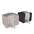 Black and Beige Vertical Pleated Ottomans Featuring Gray Blanket and Tassel Accents