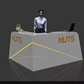 Exhibition Reception Desk Featuring White Surface Orange NUTS Logo Yellow LED Strips And Laptop