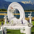 Scenic Garden Landscape With White Floral Archway Circular Ornament Pillars Lawn Lake And Mountain Backdrop