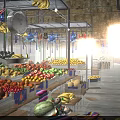 Colorful Fresh Fruits at Market Stalls With Hanging Decorations and Clock