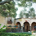 Traditional Courtyard Garden Featuring Arches Lush Greenery Trees And Outdoor Seating