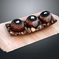 Three Decorative Candle Holders Arranged on Wooden Tray with Small Pebbles