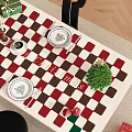 Festive Christmas Restaurant Dining Table Setup With Checkered Tablecloth Gifts And Small Trees