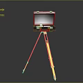 Black Electronic Device Mounted On Yellow Tripod Stand For Portable Use