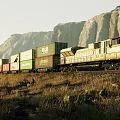 Freight Train Carrying Containers Moving Through Mountainous Landscape With Dry Grass 3d model
