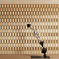 Dynamic Metallic Sculpture With Geometric Cubes On Black Base Against Light Wooden Grid Wall