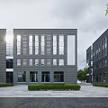 Modern Office Building With Gray Brick Exterior Numerous Windows Symmetrical Design Lawn And Trees