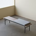 Modern Ottoman With Metal Frame Wooden Top And Gray Cushion In Corner Room With Light Wall