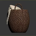 Brown Woven Basket With Two Handles Holding Beige Blanket On Gray Background