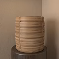 Bamboo Tea Steamer With Striped Design Placed On Wooden Table Against Beige Wall