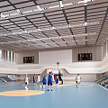Indoor Basketball Gymnasium Interior With Players Playing On Blue Court Bleacher Seating And Ceiling Design