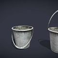 Three Different Sizes of Worn Metal Buckets with Handles on Dark Background