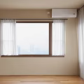 Casement Window With White Curtains Overlooking City View In Beige Wall Room With Wooden Floor