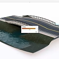 Two Lane Road Bridge With Guardrail Spanning Over Water And Green Bank
