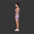 A woman wearing pink sports bra and shorts with white sneakers against gray background