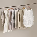 Various Beige White Gray Clothes Hanging On Wooden Hangers With Knitted Sweater And Dress