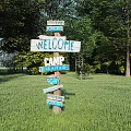 Scenic Campground With Welcome Sign River Fire Pit Toilet And Green Trees