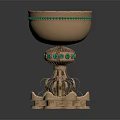Ornate Golden Cup With Green Gemstone Embellishments And Intricate Pedestal Base