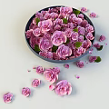 Fresh Pink Flowers in Blue Bowl with Scattered Petals on Light Surface