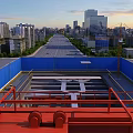Road Infrastructure Construction at Urban Site With Red Crane Structure and Blue Barriers