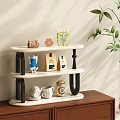 Three Tier Wooden Shelf With Coffee Bags Cups Decorative Items And Green Plant On Cabinet