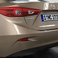 Golden Tan Sedan Car With Modern Sleek Exterior And Alloy Wheels In Indoor Showroom