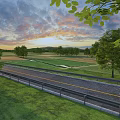 Scenic Road Infrastructure With Guardrails Green Grassland Trees And Sunset Sky