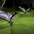 Illuminated Butterfly Shaped Outdoor Lights with Intricate Patterns in Garden Grass