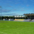 Outdoor Sports Stadium With Green Grass Field Running Track And Athletes Training For Fitness