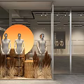Modern Window Display With Three Mannequins Orange Circular Backdrop Dried Grass And Wooden Stumps