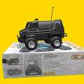 Electric Toy Remote Control Car Black with Antenna Big Wheels on Packaging Box Yellow Background