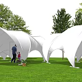 White Curved Tents in Green Grass Field With Trees and Blue Sky