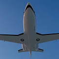 White Passenger Jet Flying In Clear Blue Sky With Sleek Wings And Windows