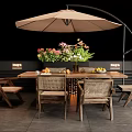Outdoor Wooden Table with Chairs Fresh Fruits Flowers Under Large Tan Umbrella on Patio
