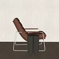 Modern Brown Leather Leisure Chair With Metal Frame And Side Table Against Light Wall