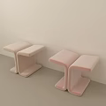 Two T Shaped Pink And Beige Stools Against Light Wall On Light Floor