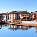 Traditional Style Homestay Building By Water With Large Wooden Waterwheel And Reflection