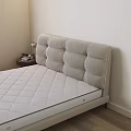 Double Bed With Light Beige Upholstered Headboard And Quilted Mattress Near Nightstand With Table Lamp