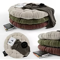 Stacked Poufs In Various Colors With Blanket Books And Hat Nearby