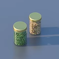 Two Spice Jars With Green And Gold Contents And Golden Lids On Blue Background
