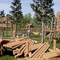 Outdoor Children's Playground With Log Climbing Structures Slide Green Lawn And Surrounding Trees