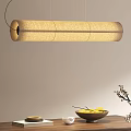 Natural Woven Long Pendant Light Over Wooden Table With Lemons Flower Branch And Books