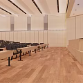 Spacious Conference Room Interior With Rows Of Black Seats Podium And Wooden Flooring
