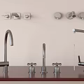 Various Styles of Modern Faucets Displayed on Countertop With Wall Mounted Control Knobs