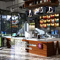 Modern Internet Cafe Interior With Bar Counter Screens And Beverage Shelves